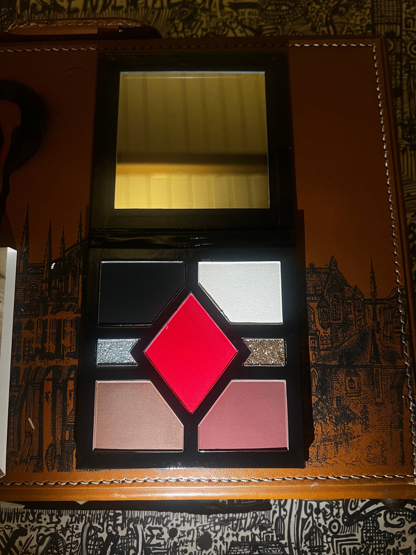 Makeup palette with various colors on a decorative background