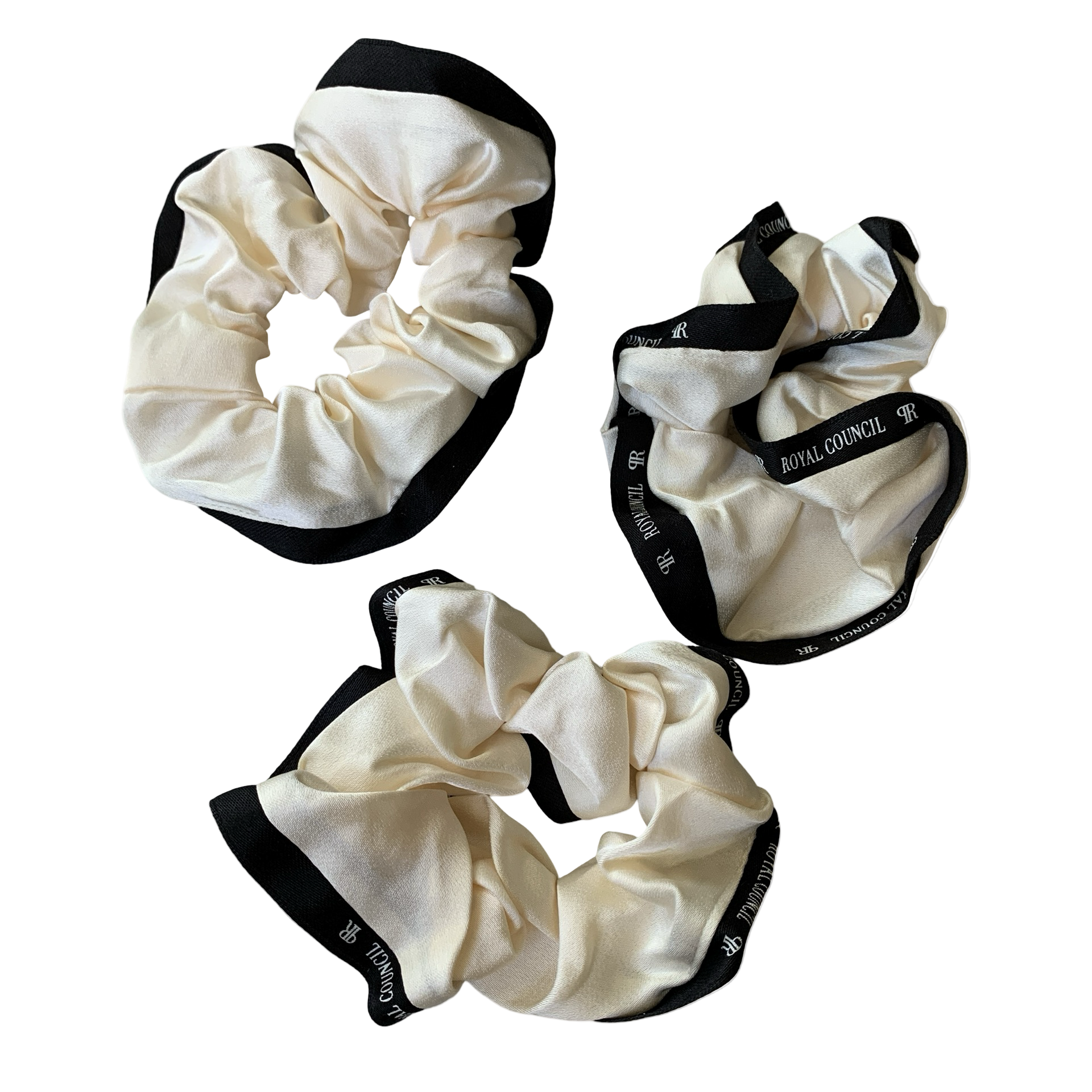 Three cream-colored scrunchies with black edges
