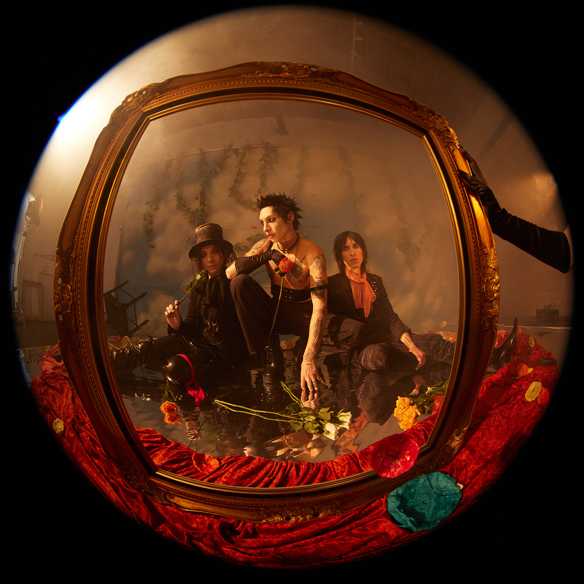 Three people sitting together with a decorative mirror reflecting their image.