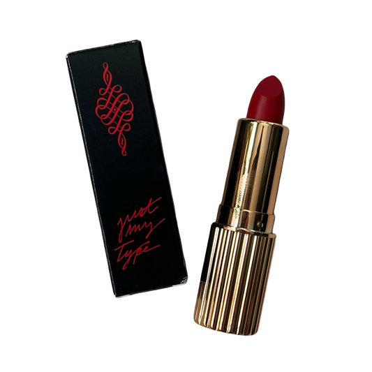 Red lipstick with gold casing and black packaging featuring red text on a white background