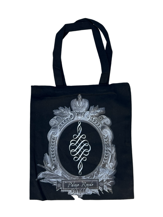 Black tote bag with decorative emblem and text on a white background