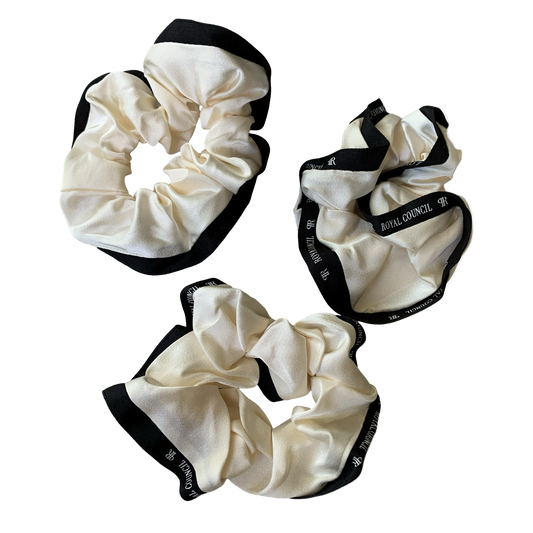 Three cream-colored scrunchies with black edges